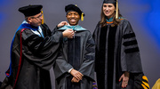 Doctor of Physical Therapy graduate Branford Barnes is hooded by Physical Therapy faculty members Jason Zafereo, Ph.D., and Emily F. Middleton, LPT, D.P.T.