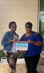 Treeca Pate and Tyesha Brown of Radiation Oncology enjoy lunch outside on a partly sunny, windy day.