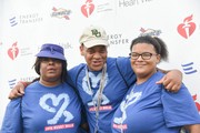 Walkers pose in front of the official AHA Heart Walk backdrop.
