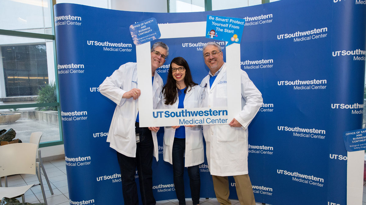 UTSW take picture for social media together inside of promotional frame cutout