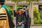 Dr. Jackson Agraz receives his hood from Dr. Sulistio.