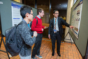 Medical student Vishal Gokani shows his research poster to medical students Galen Gao and Patrick Lynch.