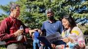 Members of the UTSW community look over the souvenir program from the event.