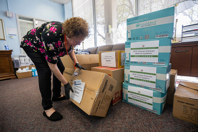 Woman in colorful print shirt adjusting cardboard box