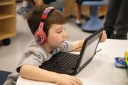 A student intently studies his lesson plan on a laptop.