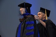 Dr. Luke Rice, Associate Professor of Biophysics and Biochemistry, hoods Dr. Anna Lee, who earned a doctorate in molecular biophysics.