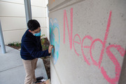 Medical student Saul Perez works on his chalk illustration outside the staff entrance of Clements University Hospital.