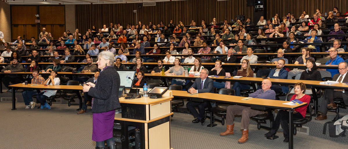 Woman speaking to an auditorium of people