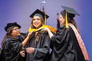 Drs. Samarpita Sengupta and Bethany Grubb, Assistant Professors in the School of Health Professions, hood Physician Assistant Studies graduate Alexandria Casanova Zepeda.