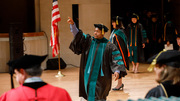 Dr. Cameron Holmes walks across the stage in celebration of receiving his M.D.