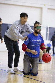 Participant and volunteer aiming for a strike