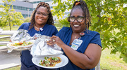 Laqueshia Hawkins and Rhonda Dobbs display their freshly prepared tacos from Santos Tacos food truck at the Festival de Comida event in to celebrate Hispanic Heritage Month.