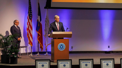 man in suit standing at podium