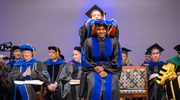Umaru Barrie, M.D., Ph.D., is hooded by his mentor, Dawn Wetzel, M.D., Ph.D., Assistant Professor of Pediatrics and Biochemistry.
