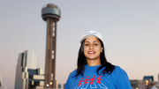 A walker poses with Reunion Tower in the background.