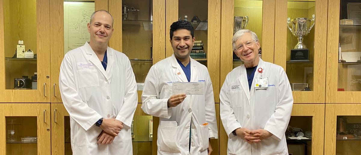 Three men in white lab coats