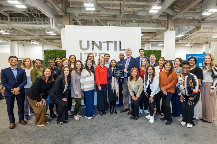 large group of members of the UTSW cystic fibrosis program holding Quality Improvement Award plaque
