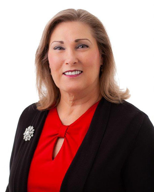 Woman with brown shoulder-length hair, black sweater, and red shirt.