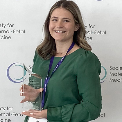 Dr. Thiele shows Society of Maternal Fetal Medicine’s Disparities Award for Best Research on Diversity/Disparity in Health Outcomes that her team won earlier this year.