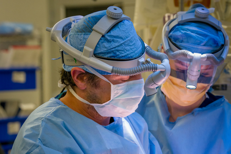 Two surgeons performing operation previewing the September 2018 Issue