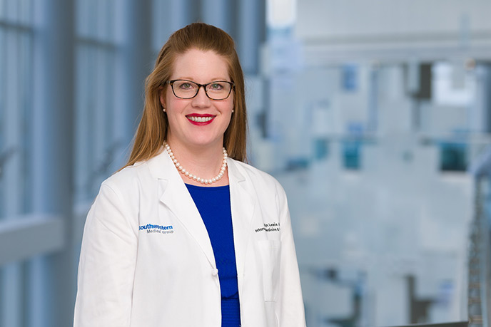 Woman wearing glasses, blue dress, and a lab coat