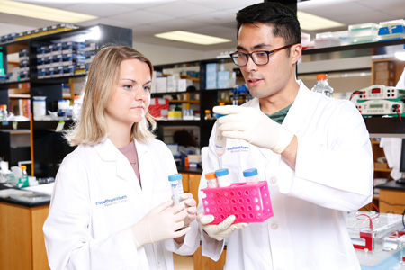 male and female students in white lab coats