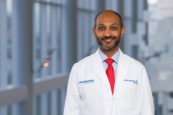 Man with trim beard, red tie, and labcoat on