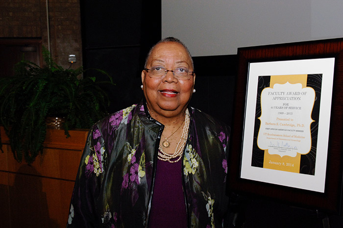 Woman standing next to award plaque