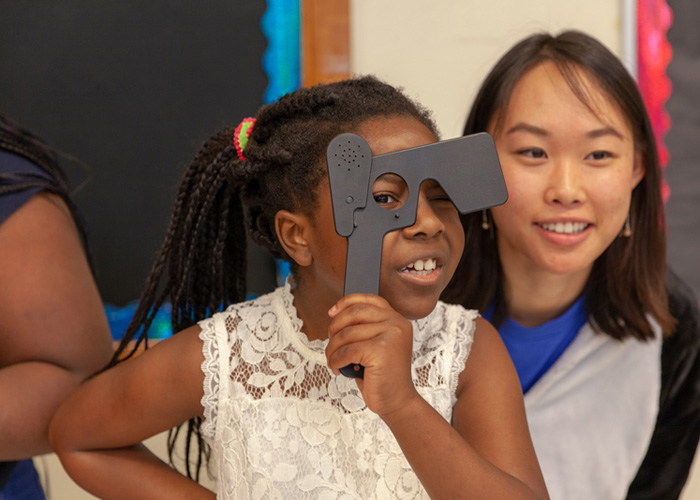 Third grader Vhinu Womeni (left) takes a closer look, along with first-year medical student Angela Zhang.