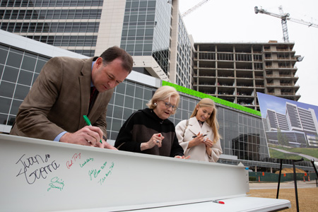 Attendees signing construction beam