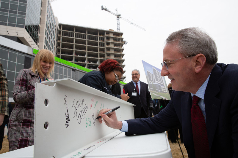 Dr. Warner signing support beam at milestone ceremony