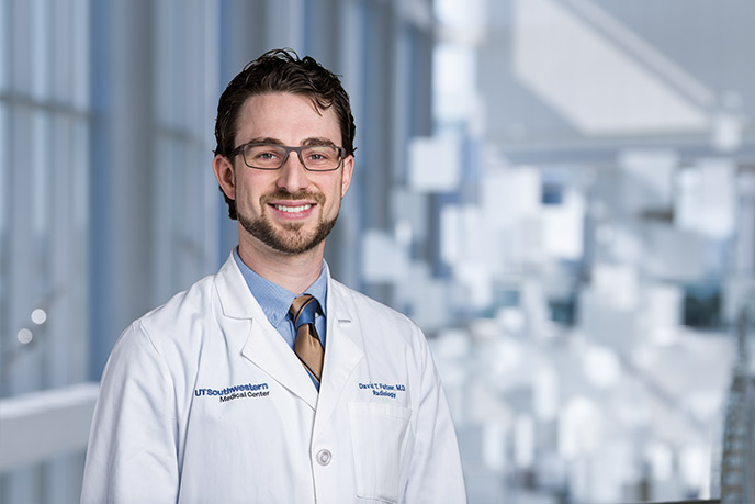 Man with glasses, beard, labcoat against a green background