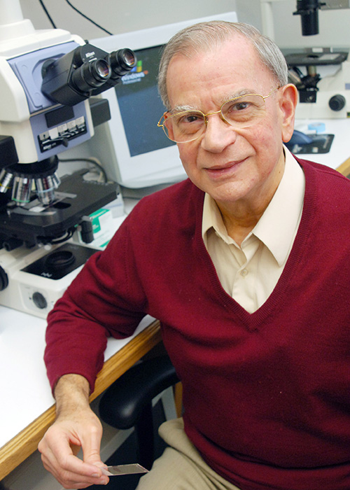 Dr. Adi Gazdar seated in lab