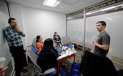 hackathon team brainstorming in front of dry erase board