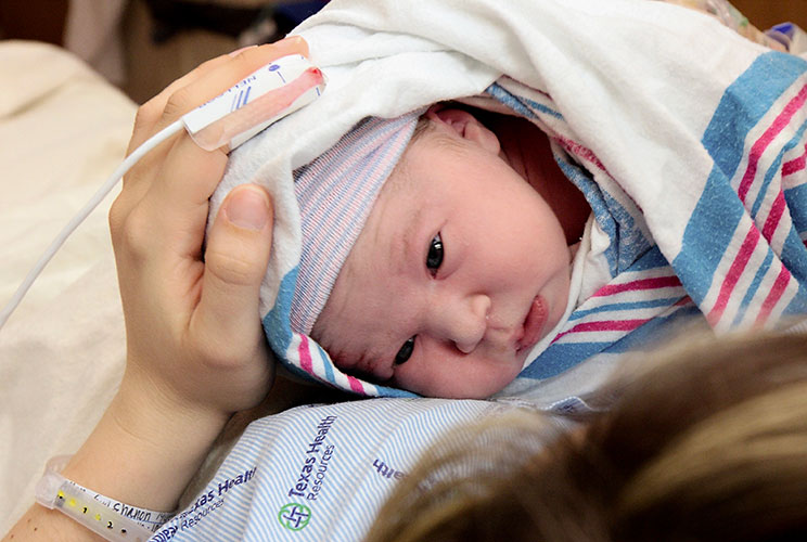 Baby Zoe Geddie being held in hospital bed