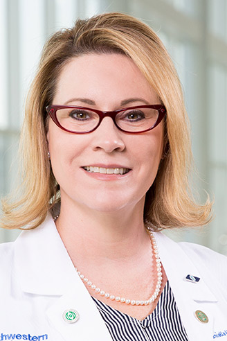 Woman with glasses, blond hair, and a labcoat