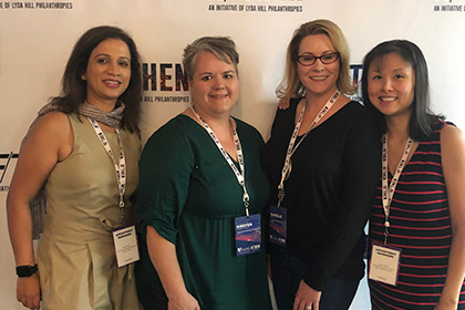 Four women standing against wall