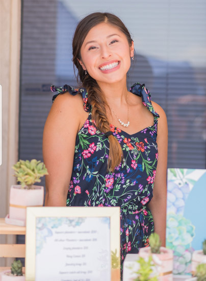 Woman sitting at table behind sign