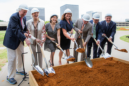 men and women in hard hats and shovels