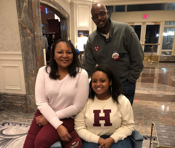 Mother, father, and daughter sitting on a chair together