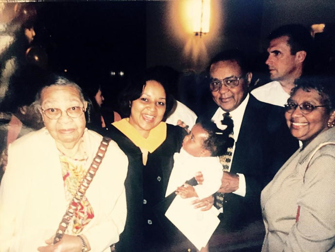 Woman with coat and yellow collar surrounded by family members
