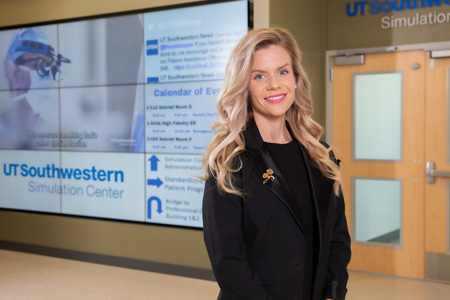 Woman in black suit standing in front of simulation center