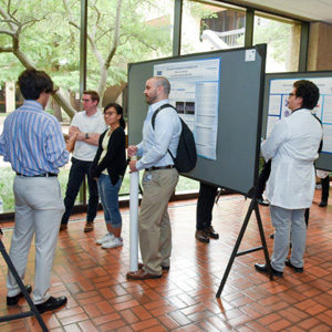 Visiting students reviewing lab presentations mounted on rolling billboards