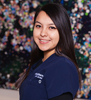 Woman with long black hair wearing UTSW scrubs