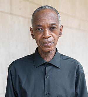 Man with short greying hair wearing dark collared shirt