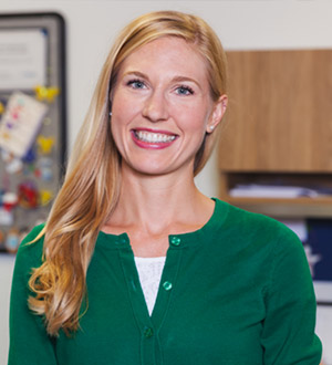 Woman with long blond hair and green shirt