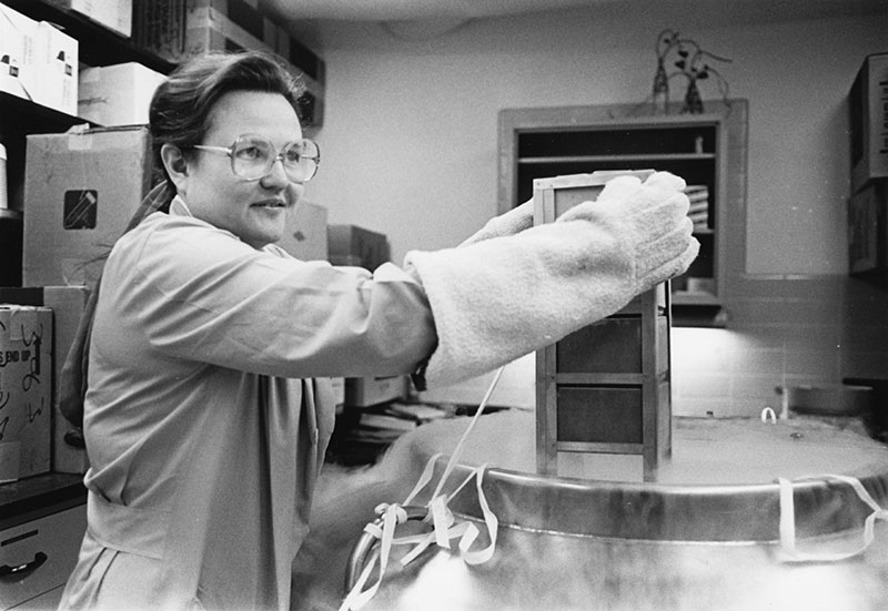 Ellen Heck, back in the tissue bank’s early days, removing a storage container of skin grafts from a liquid nitrogen freezer.