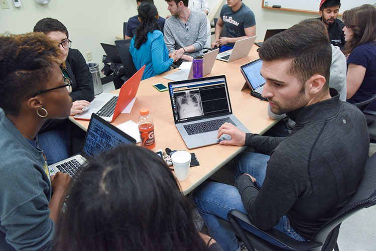 UTSW Grad Students sitting around table discussing xray images