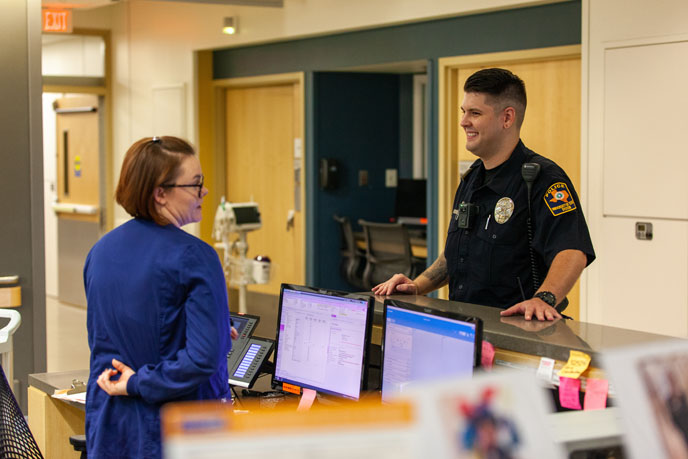 Police officer talking to person at nurse's station