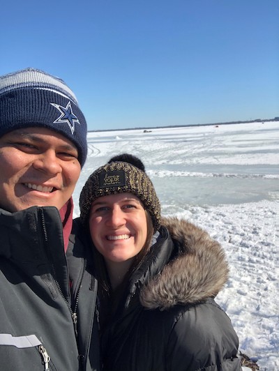 Man and woman wearing winter clothing smiling on frozen lake